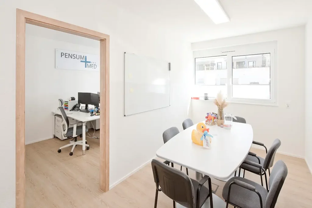 Besprechungsraum bei Pensum MED Gärtringen mit Büromöbeln und Blick ins Büro mit Firmenlogo