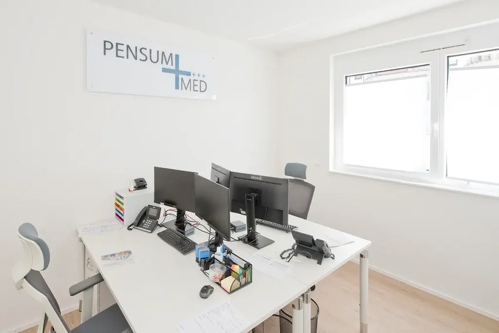 Helle Büroräume mit mehreren Arbeitsplätzen und Monitoren im Standort von Pensum MED Gärtringen.