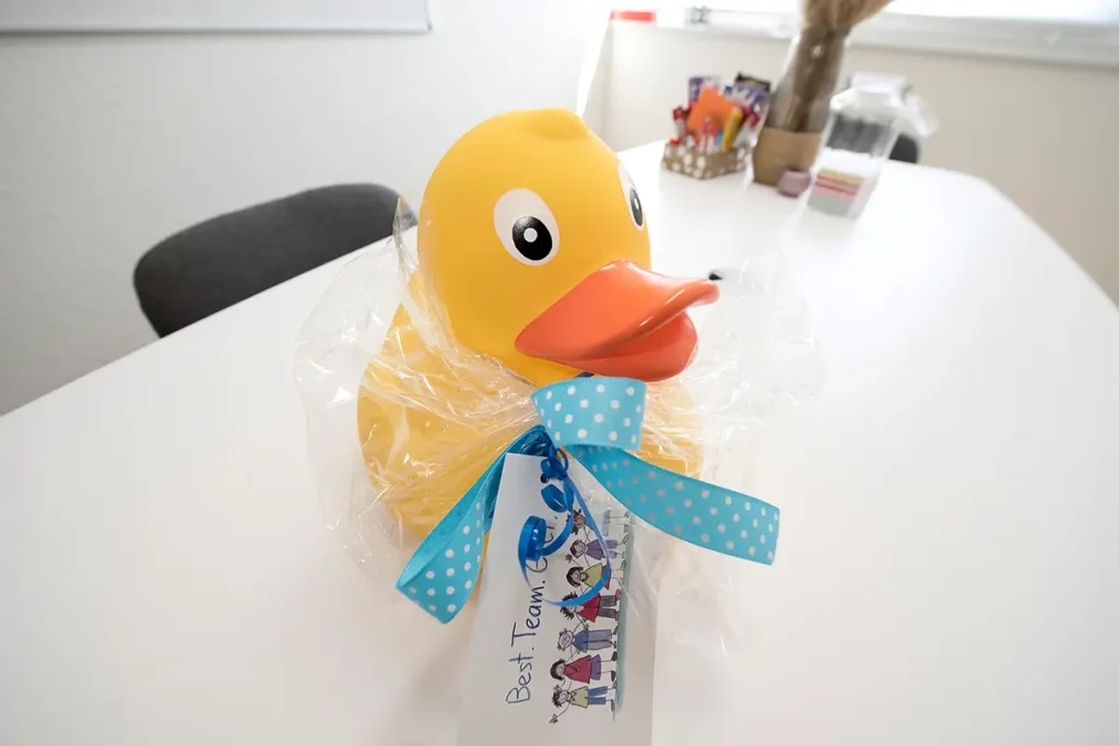 Teamgeschenk gelbe Ente mit Schleife im Besprechungsraum von Pensum MED Gärtringen.